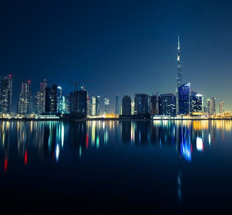 Dubai skyline reflected in still water at night (illustrative photo) – not a photo of Jumeirah Lake Towers